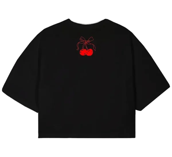 Polo crop con diseño de cerezas brillantes, tipografía roja estilo vintage con la palabra "CHERRIES" y el mensaje "Be Unique". Estilo juvenil y moderno.
